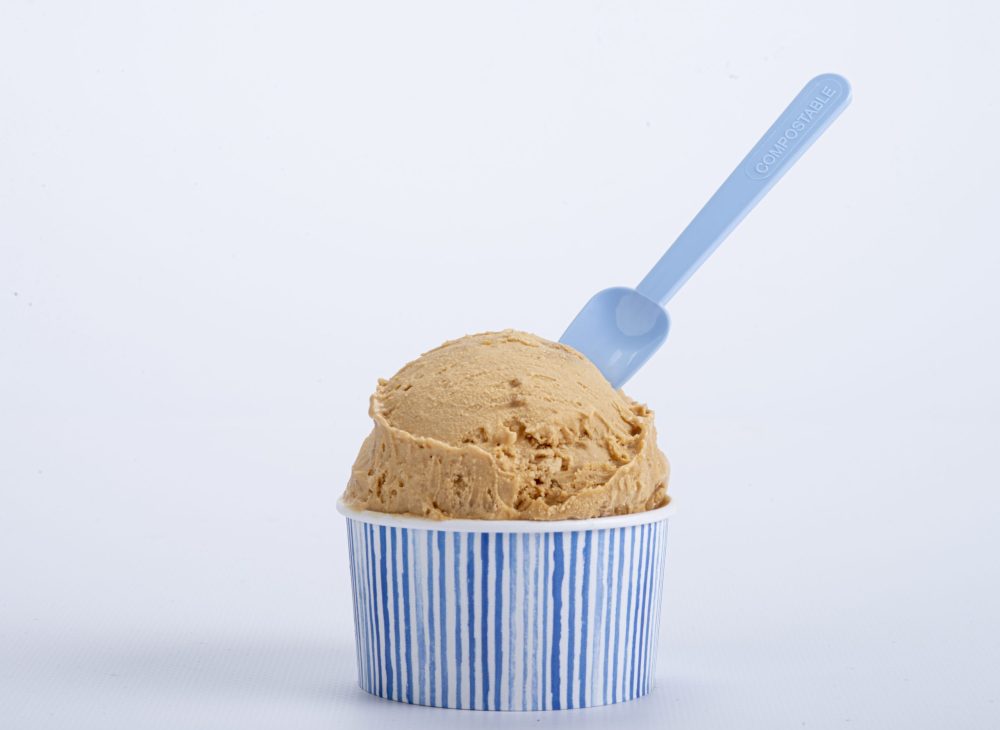 Cucharita compostable azul en helado de chocolate